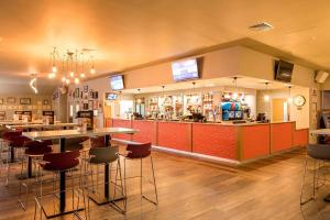 a restaurant with tables and chairs and a bar at New beach holiday park in Dymchurch