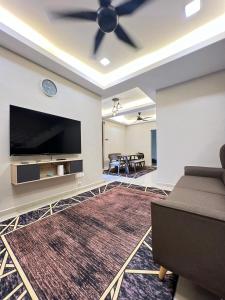 RR Homestay Yong Peng في Yong Peng: غرفة معيشة مع مروحة سقف وتلفزيون بشاشة مسطحة