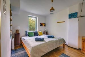 een slaapkamer met een bed met blauwe kussens erop bij HillSide Gasthaus 2 a Szent György-hegy lankáin in Tapolca