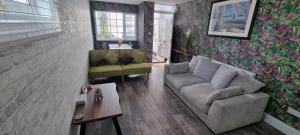 una sala de estar con un sofá y una mesa en The Hideaway ll private garden Quiet Central, en Southport