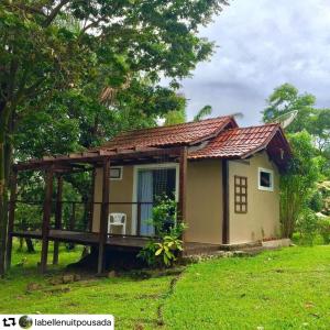 uma pequena casa com um telhado num campo verde em Pousada das Palmeiras em Salinópolis