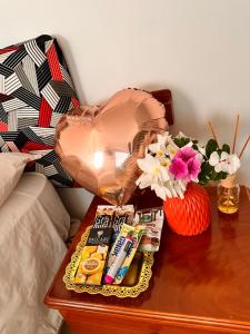 una mesa con una lámpara en una mesa con cosméticos y flores en Stefany's Lodging, en Puerto Baquerizo Moreno
