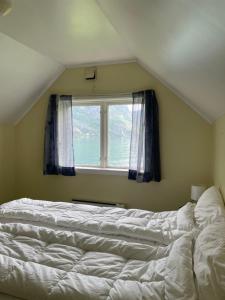 a bedroom with a white bed and a window at Aurland Feriehus in Aurland