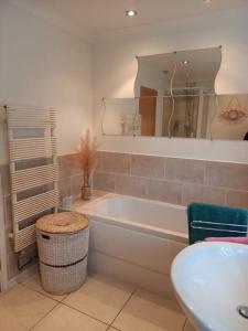 a bathroom with a tub and a sink and a mirror at Modernised home with 2 bedrooms in Cardiff in Cardiff