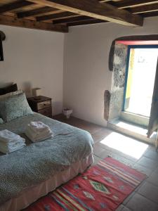 a bedroom with a bed and a window at Casa da Lapa in Angra do Heroísmo