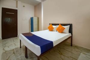 Bett in einem Zimmer mit orangefarbenen und blauen Kissen in der Unterkunft SPOT ON 66974 Hotel shri gurukripa in Gwalior
