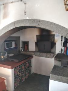 eine Küche mit einem steinernen Torbogen in der Wand in der Unterkunft Casa da Lapa in Angra do Heroísmo