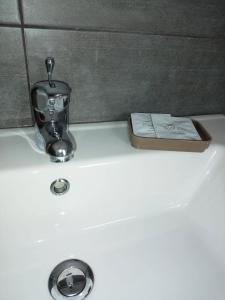 lavabo con grifo y libro en Granatelli Holiday Home, en Altavilla Milicia