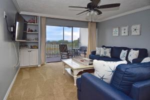 a living room with a blue couch and a table at Direct Beachfront Delight in Siesta Key