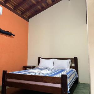 Schlafzimmer mit einem Bett mit orangefarbenen und weißen Wänden in der Unterkunft Pousada Recanto Janbor in Olímpia