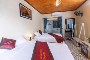 una camera d'albergo con due letti e uno specchio di Tam Coc Charming 2 a Ninh Binh