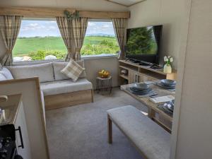 a living room with a couch and a tv at Yoda's Staycation in Barrowford
