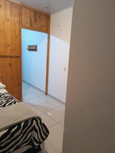 a bedroom with a bed and a door to a room at Pousada Tertulia Apartamento completo em Lages! in Lages