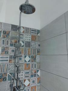 y baño con ducha y pared de azulejos. en Granatelli Holiday Home, en Altavilla Milicia