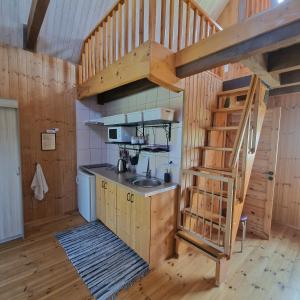 a kitchen with a staircase in a wooden cabin at Dobilas ir jura in Palanga