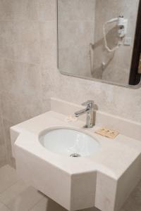 Hayah Salam Silver Hotel في المدينة المنورة: بالوعة بيضاء في الحمام مع مرآة
