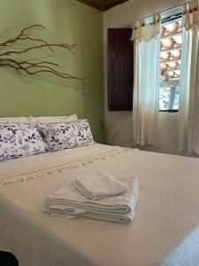 a bedroom with a bed with towels on it at Casas Goiás - Suítes Beira Rio - Centro Histórico in Goiás