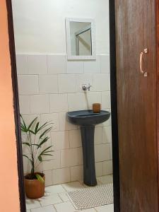 y baño con lavabo azul y espejo. en Casas Goiás - Suítes Beira Rio - Centro Histórico en Goiás