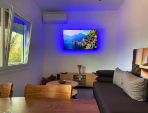 a living room with a couch and a tv on the wall at Adams Apartments in Skala Rachoniou