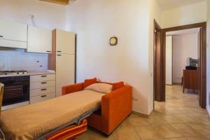 a kitchen with an orange couch in a room at Casa Vacanze Dalisa Ulivo A con parcheggio in Tramonti +5 photos