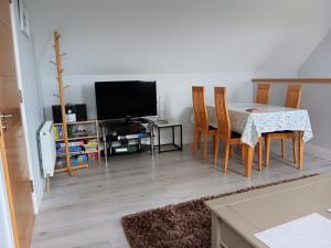 ein Wohnzimmer mit einem Tisch mit Stühlen und einem TV in der Unterkunft Duplex/2 Bedrooms on Kildare/Carlow/Laois Border in Carlow