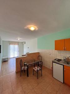 a kitchen with a table and chairs in a room at GuestHouse Moco Forest in Ulcinj