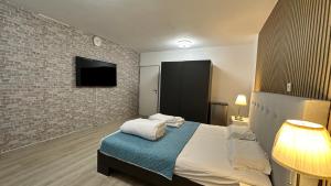1 dormitorio con cama y pared de ladrillo en Cloud9, en Dreieich