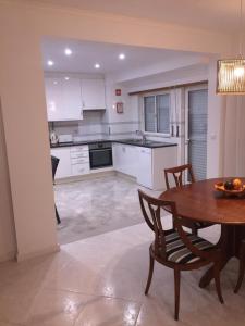 a kitchen with a wooden table and a table and chairs at Onda Verde in Albufeira