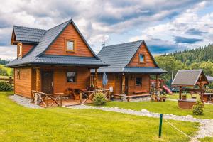 Cabaña de madera con porche y parque infantil en Domek na Leśnej en Łapsze Niżne