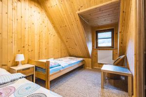 um pequeno quarto com uma cama num chalé de madeira em Domek na Leśnej em Comuna de Łapsze Niżne