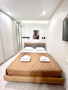 een slaapkamer met een bed met twee handdoeken erop bij Smart Lux Apartment A in Athene