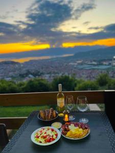 una mesa con dos platos de comida y vino en Villa & Apartments Cityview Ohrid, en Ohrid