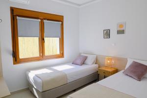 a bedroom with two beds and a window at SeaPearl in Paralía Avdhíron