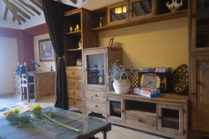 a room with a wooden cabinet and a glass table at La Laguna in Almedinilla