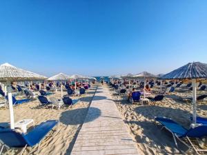 a boardwalk on the beach with chairs and umbrellas at SeaPearl in Paralía Avdhíron