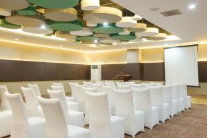 Go Hotels Lanang - Davao في مدينة دافاو: قاعة اجتماعات مع كراسي بيضاء ومنضدة
