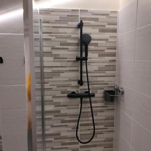 a shower with a shower head in a bathroom at Chambres d'hôtes d'Antardieu in Saint-Junien