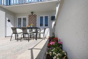 eine Terrasse mit Tisch und Stühlen und Blumen in der Unterkunft MIA Family Apartments Punat in Punat