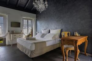 a bedroom with a bed and a table and a chandelier at Agriturismo Treterre in Pianello Del Lario