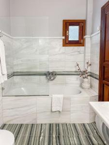 uma casa de banho branca com uma banheira e um lavatório em ClubOrsa Ourania's Mansion em Skiathos