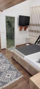 a bedroom with a bed and a flat screen tv at Salillari Guest house & Restaurant in Berat