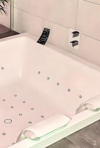 bañera blanca en una habitación en LOFT & SPA PRIVATIF, en Dijon