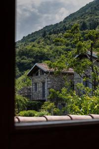 a stone house in front of a mountain at Agriturismo Treterre in Pianello Del Lario