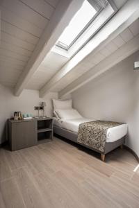 a attic bedroom with a bed and a skylight at Agriturismo Treterre in Pianello Del Lario