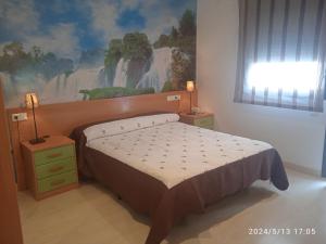1 dormitorio con 1 cama y una pintura en la pared en Hotel Restaurante Caracho en Corella