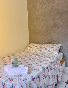 a small bedroom with a bed with a white comforter at Pousada Sempre Viva Lençóis in Lençóis