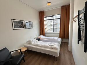 twee bedden in een kamer met een raam bij Guesthouse Pavi in Reykjavík