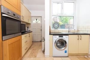 a kitchen with a washing machine and a window at Suite 3 - Trendy Private Room near City Centre in Manchester