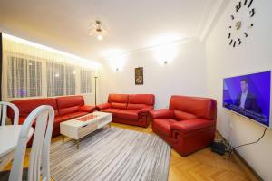 sala de estar con sofás rojos y TV en Apartament Erisa en Peje