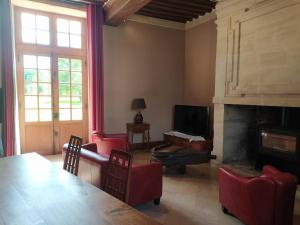 a living room with red chairs and a fireplace at Gîtes La Grande Ferme Crépon - à la campagne 5mn d'Arromanches et 10mn de Bayeux in Crépon